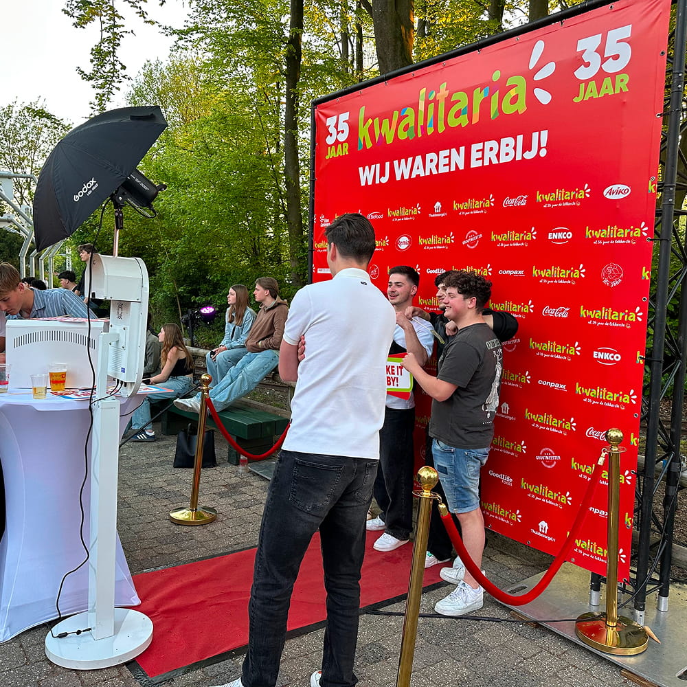 De zuil met flitser en rode loper bij een backdrop op een buitenevent